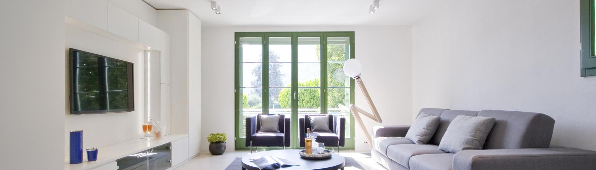 Helles Wohnzimmer mit modernen Möbeln und grünem Ausblick.