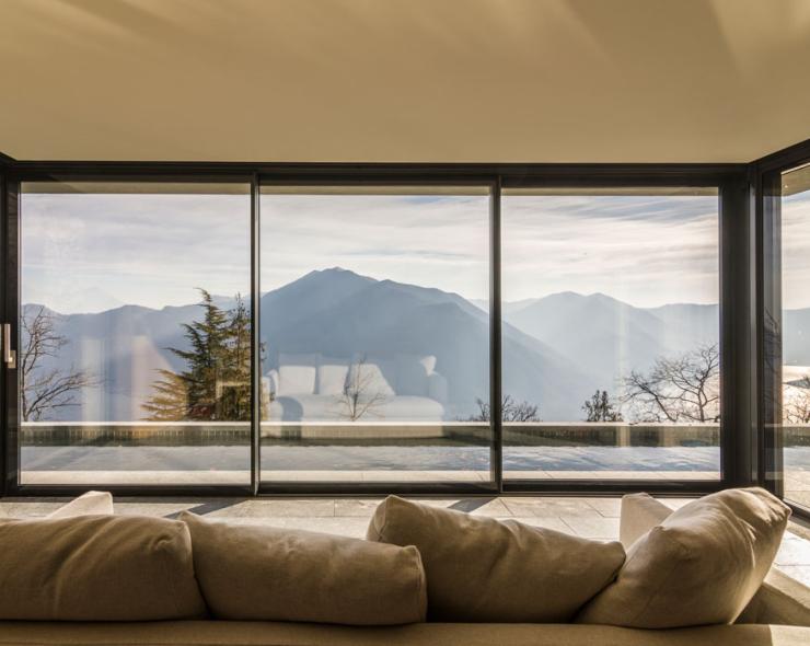 Breathtaking view of serene mountains from an elegant living room with large windows.