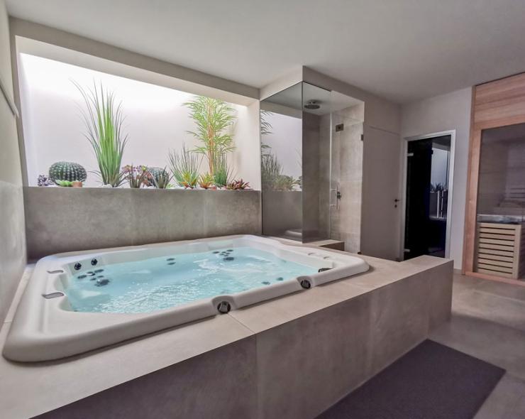 Luxuriöses Spa mit Whirlpool, Sauna und exotischen Pflanzen für totale Entspannung.
