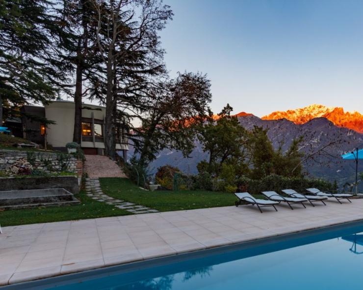 Pool bei Sonnenuntergang mit Bergblick, warme Farben, friedliche Atmosphäre.
