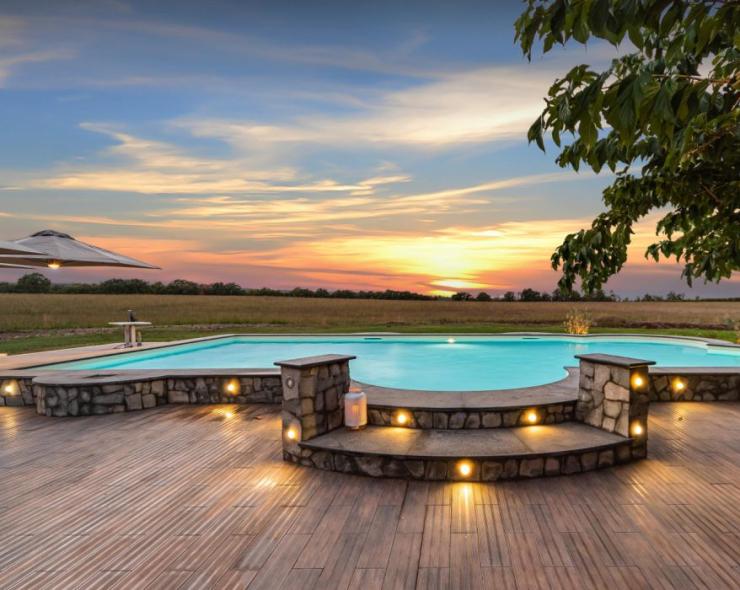 Pool bei Sonnenuntergang mit sanfter Beleuchtung und friedlicher Landschaft.